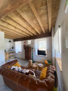 una sala de estar con un gran sofá de cuero marrón en APARTAMENTOS KERCUS, en Sevares