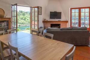 un soggiorno con un tavolo e un divano di Castelo de Bode - Lake House, A Casa do Avô a Levegada