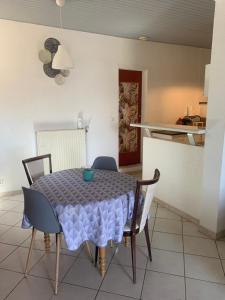 a dining room table and chairs with a blue table cloth at Maison cocoon avec jacuzzi privé vue Dordogne in Castillon-la-Bataille