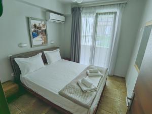 a bedroom with a bed with two towels on it at Bella Vista Apartments Keramoti in Keramoti