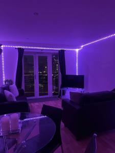 a living room with purple lighting and a couch at 2 bedroom luxury apartment Birmingham city centre in Birmingham