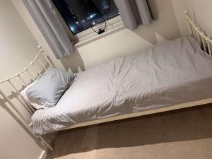 a small bed in a room with a window at 2 bedroom luxury apartment Birmingham city centre in Birmingham
