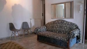 uma sala de estar com uma cadeira e um espelho em Maria Apartments em Paralia Dionysiou