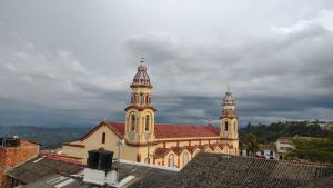 a large church with two towers on top of roofs at HOTEL DEL PARQUE VELEZ Santander in Vélez +47 photos