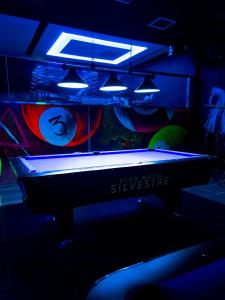 - une table de billard dans une pièce sombre éclairée dans l'établissement Hotel Silvestre, à La Romana