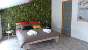 1 dormitorio con 1 cama frente a una pared con flores en Maison de Vacances 8 à 15 pers à proximité du Canal du Midi, en Sallèles-dʼAude