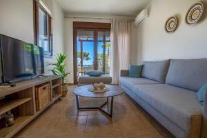 a living room with a couch and a tv and a table at Villa Sunrise in Kiotari