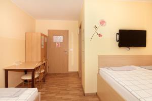 Habitación con mesa, cama, mesa y sillas. en Beg Rooms, en Maribor