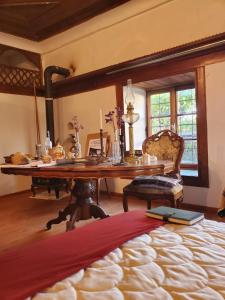 a room with a wooden table and a desk with a bed at Historic Albanian House in Shkodër