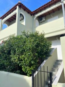 a house with a bush in front of it at Perdika's Nest, family friendly house by the sea in Perdika