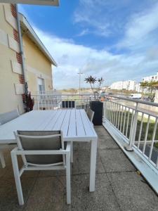 un tavolo bianco e una sedia sul balcone di Appartement front de l'océan a Soulac-sur-Mer