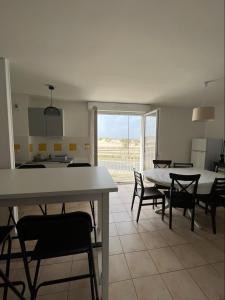 una cucina e una sala da pranzo con tavolo e sedie di Appartement front de l'océan a Soulac-sur-Mer