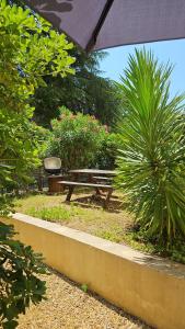 a picnic table and a bench in a park at T4 Proche centre et plages Jacuzzi et Parking gratuit in Montpellier