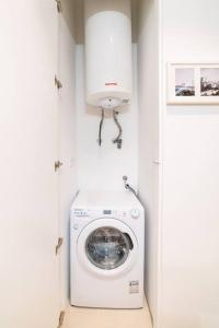 a washer and dryer in a white laundry room at Amaro III - Stunning penthouse apartment in Alcantara in Lisbon