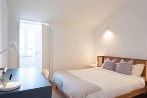 a bedroom with a bed and a desk and a window at Amaro III - Stunning penthouse apartment in Alcantara in Lisbon