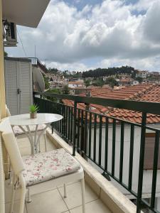 balcón con mesa, mesa y sillas en Arya Guesthouse en Poligiros