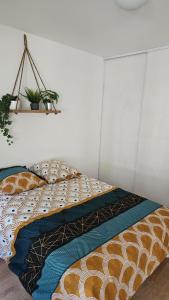 ein Bett mit einer Bettdecke und Kissen darauf in der Unterkunft T4 Proche centre et plages Jacuzzi et Parking gratuit in Montpellier