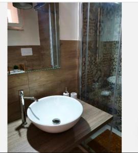 La salle de bains est pourvue d'un lavabo blanc et d'une douche. dans l'établissement B & B VIA ROMA, à Ercolano