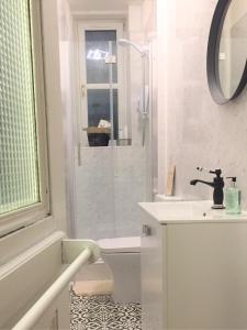 a white bathroom with a shower and a sink at Glamours stylish Victorian apartment near city centre in Edinburgh