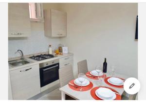 - une cuisine avec une table et des plaques rouges et blanches dans l'établissement B & B VIA ROMA, à Ercolano