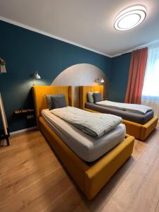 Sofia Apartment & Zimmer في Sillweg: سريرين في غرفة بجدران زرقاء