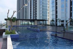 a pool in the middle of a city with tall buildings at Galeno Pollux Habibie in Batam Center