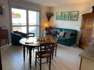 a living room with a table and a green couch at Charming flat just outside Paris w free Private Parking in Saint-Ouen