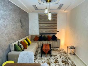 a living room with a couch with colorful pillows at Appartement INES Saidia in Saidia 