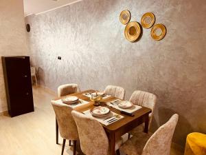 a dining room with a wooden table and chairs at Appartement INES Saidia in Saidia 