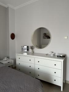 um quarto com uma cómoda branca com um espelho em Arya Guesthouse em Poligiros