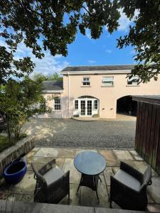 a patio with a table and chairs in front of a building at The Cottage at Riverbank in Ballinamallard