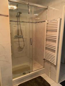 a shower with a glass door in a bathroom at Charming flat just outside Paris w free Private Parking in Saint-Ouen +12 photos