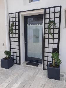 een deur met twee potplanten ervoor bij Urban79 in Bernalda