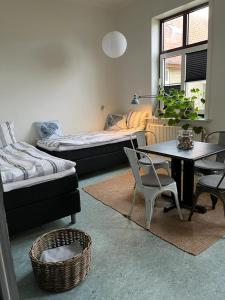uma sala de estar com duas camas e uma mesa e cadeiras em Room 14 - Hawkraft kulturhotel em Vestervig