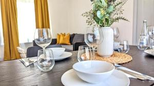 a dining room table with wine glasses and a vase at Spacious home near Newcastle City Centre in Hebburn-on-Tyne