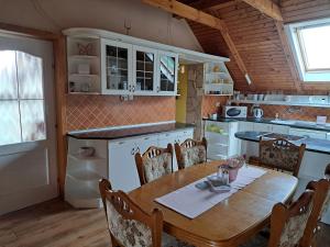 a kitchen with a wooden table and a dining room at Kismarosi Center Apartman in Kismaros