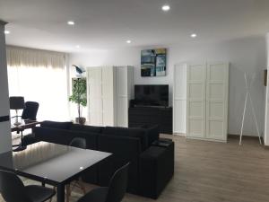 - un salon avec un canapé noir et une table dans l'établissement New Casa Praia da Rocha, à Portimão