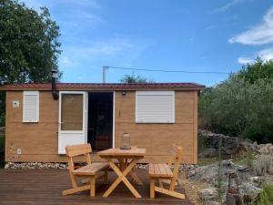 a cabin with a table and two chairs on a deck at Tiny house & Glamping tent in Kotor