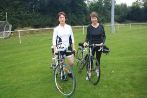 two women standing with their bikes on a field at Blackrath Farmhouse in Dún Luáin