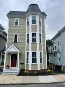 a large green house with a gray roof at Brand New Luxury Rooms near downtown Boston in Boston