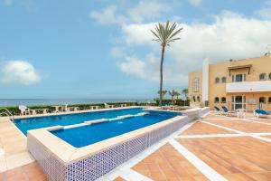 une villa avec une piscine et un palmier dans l'établissement Estepona Beach Apartment, à Estepona