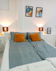 a large bed with blue sheets and orange pillows at Жути ранац / Yellow Backpack in Boljevac