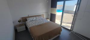 - une chambre avec un lit et une vue sur la plage dans l'établissement Chalet con piscina, terraza y barbacoa, à Pallaresos