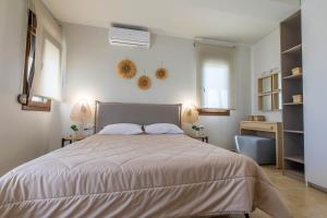 a bedroom with a large bed with two lamps on the wall at Villa Sunrise by the Sea in Kiotari +68 photos