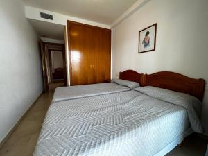 een slaapkamer met een groot bed met een houten hoofdeinde bij Gemelos 22-Fincas Benidorm in Benidorm