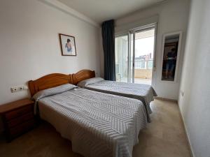 1 dormitorio con 2 camas y ventana en Gemelos 22-Fincas Benidorm, en Benidorm