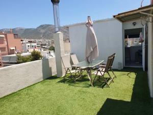 雅典的住宿－Skyline oasis rooftop，庭院配有桌椅和遮阳伞。
