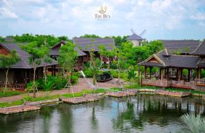 a group of houses on the water with a windmill at THƯ DUY Resort in Cà Mau