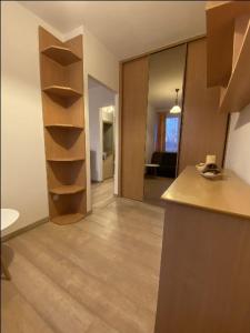 a room with a kitchen with a counter and shelves at Apartament Na Piątkę in Sopot