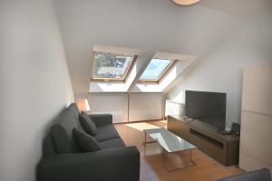 a living room with a couch and a tv at BICOS ao MAR in Rianjo